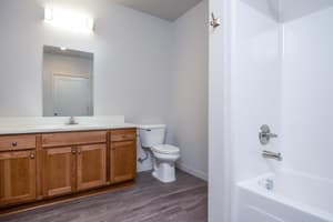 Bathroom with wood cabinets and large mirror at 459 Rock Apartments, 459 SE 192nd Ave, Gresham, Oregon 97233