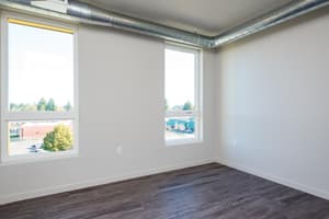 Bedroom with large windows and hardwood floors at 459 Rock Apartments, 459 SE 192nd Ave, Gresham, Oregon 97233