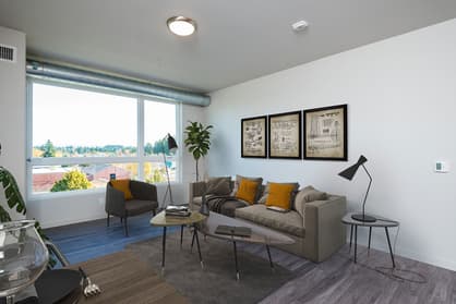 Staged living room with large windows at 459 Rock Apartments