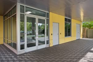 Exterior with glass entrance, yellow paneling at 459 Rock Apartments, 459 SE 192nd Ave, Gresham, Oregon 97233