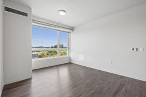 Three-bedroom apartment living room with large window at 459 Rock Apartments