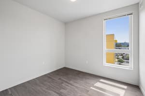 Bedroom with large window, hardwood floors at 459 Rock Apartments, 459 SE 192nd Ave, Gresham, Oregon 97233