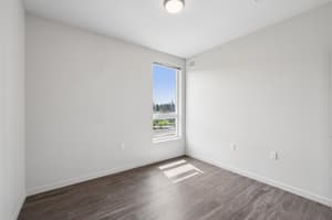Bedroom with large window, hardwood floors at 459 Rock Apartments, 459 SE 192nd Ave, Gresham, Oregon 97233